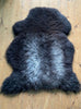Dark brown sheepskin rug on wooden floor