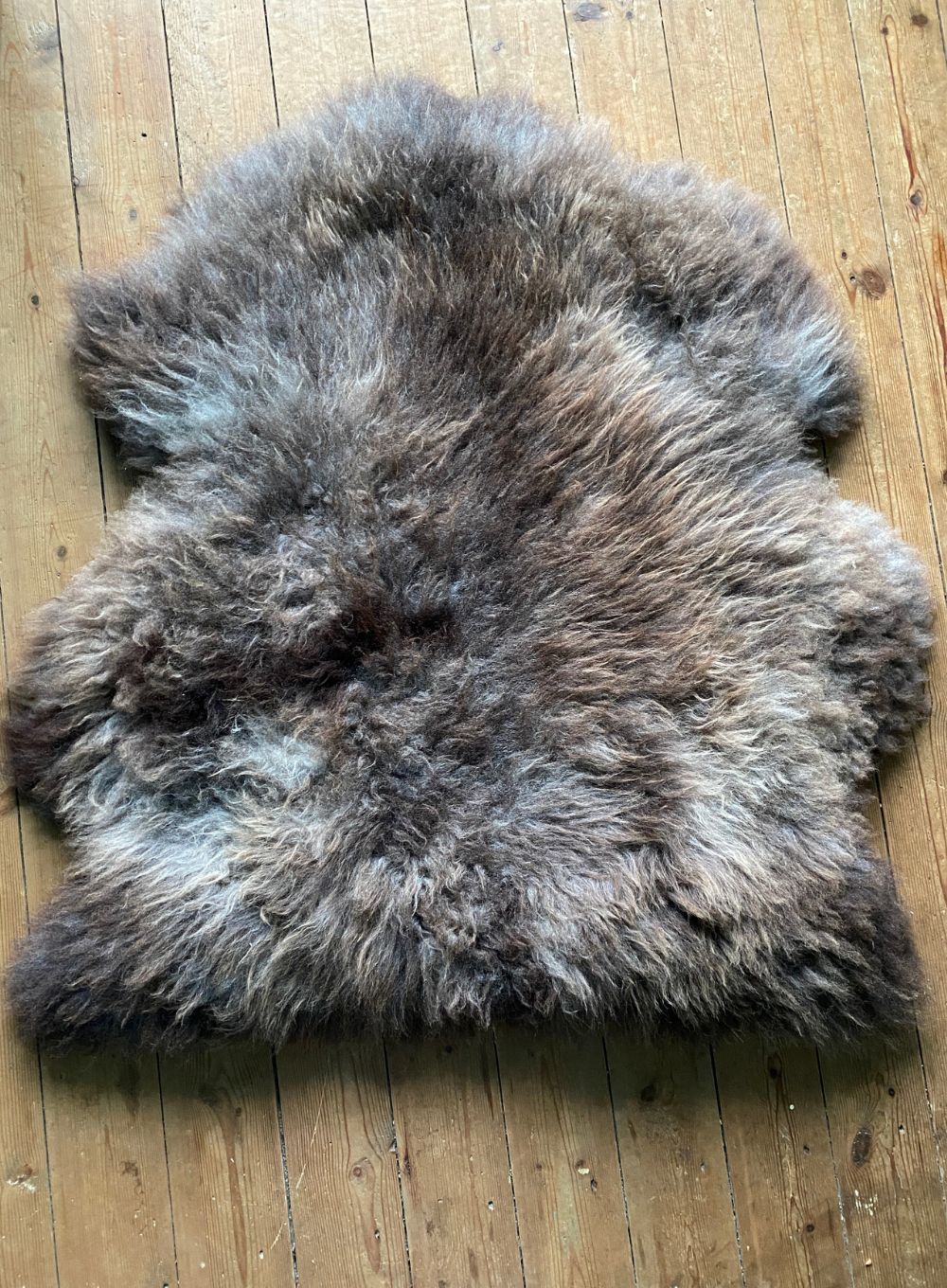 Brown sheepskin rug on wooden floor