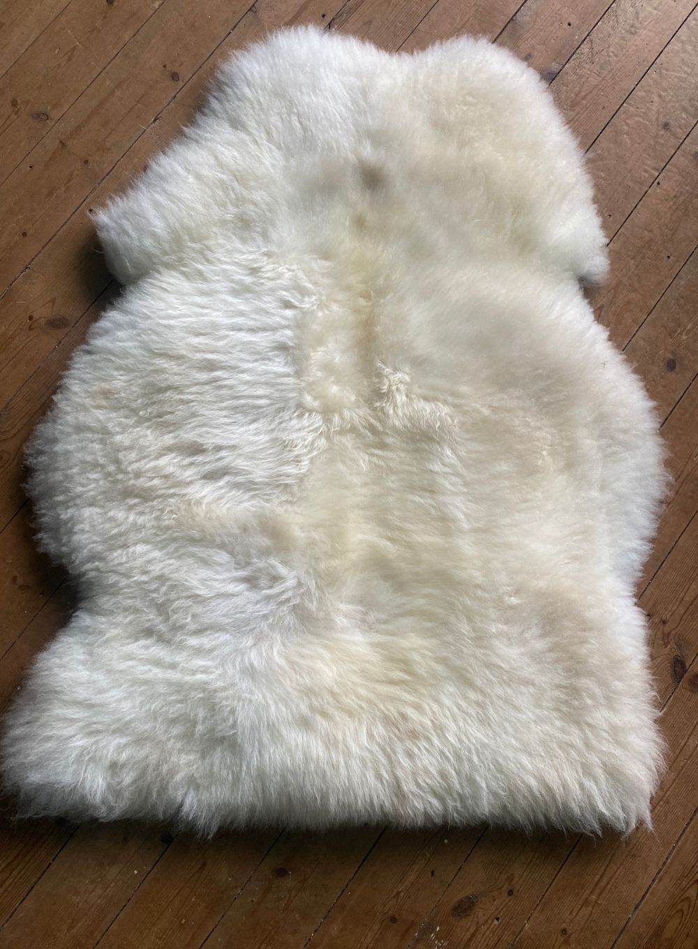 Cream sheepskin rug on wooden floor