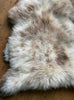 Cream speckled sheepskin rug close up