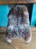 Brown and grey sheepskin rug on chair 