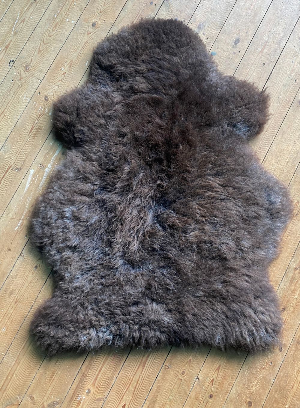 Brown sheepskin rug on wooden floor