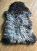 Grey sheepskin rug on wooden floor