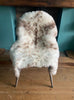 Cream speckled sheepskin rug on chair