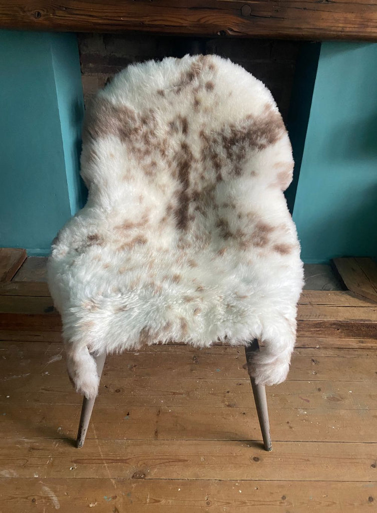 Cream speckled sheepskin rug on chair