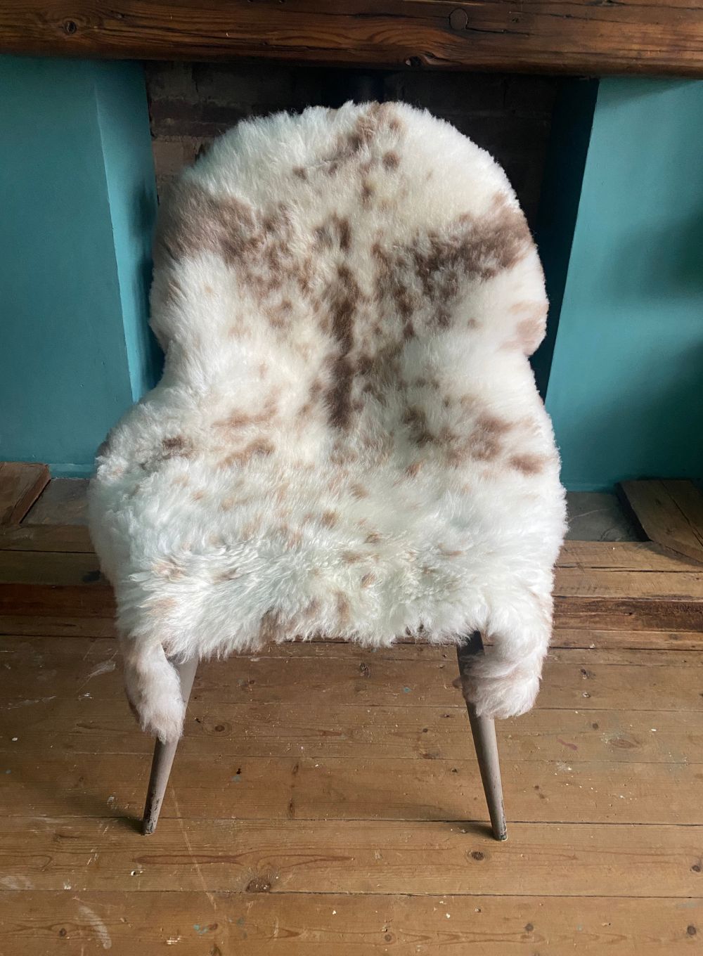 Cream speckled sheepskin rug on chair