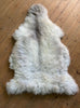 Cream sheepskin rug on wooden floor 