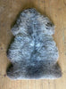 Brown and grey sheepskin rug on wooden floor