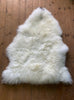Cream sheepskin rug on wooden floor