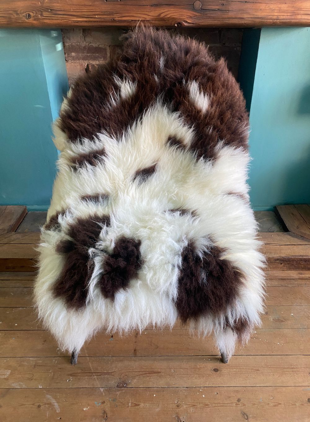 Brown and cream spotty sheepskin rug on chair