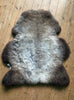 Grey and brown sheepskin rug  on wooden floor 