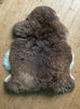 Brown sheepskin rug on wooden floor