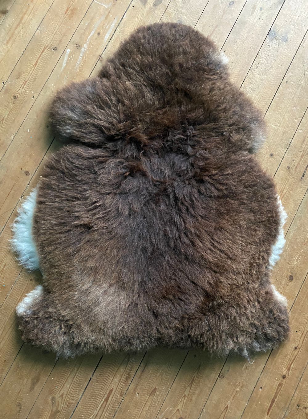 Brown sheepskin rug on wooden floor