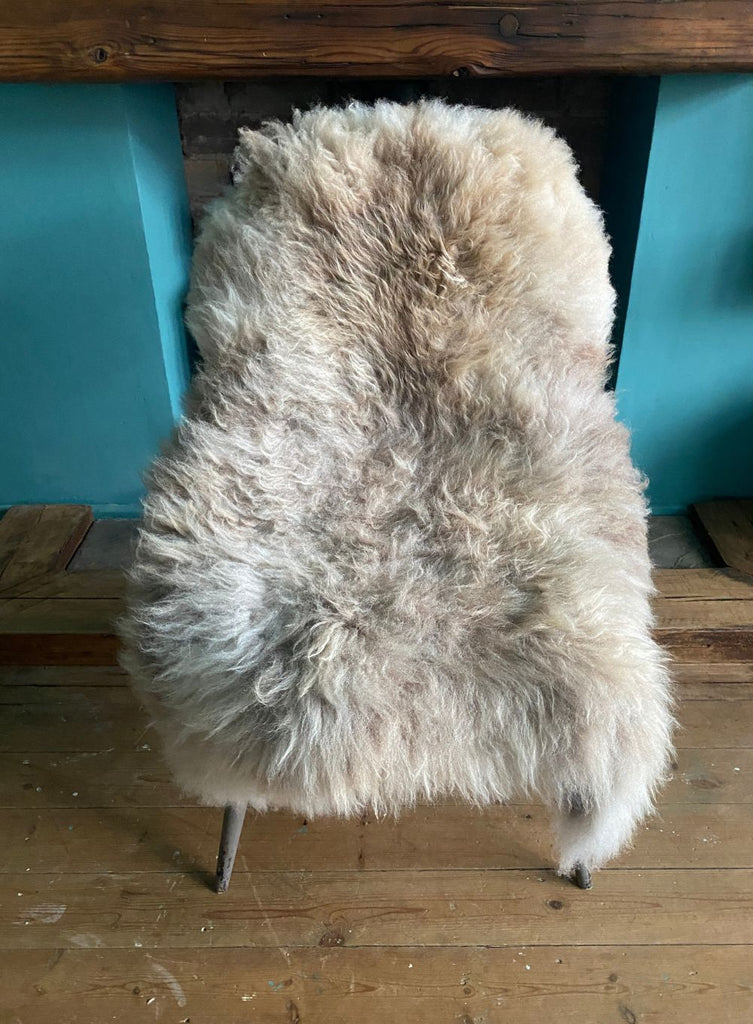 Cream speckled sheepskin rug on chair