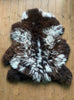 Brown and cream sheepskin rug flat on wooden floor