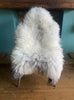 Cream speckled sheepskin rug on chair