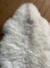 Cream speckled sheepskin rug close up