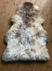 Cream speckled rug on wooden floor