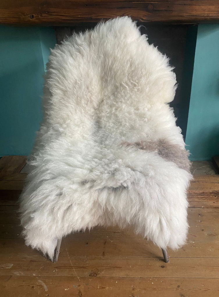 Cream sheepskin rug with brown spot on chair