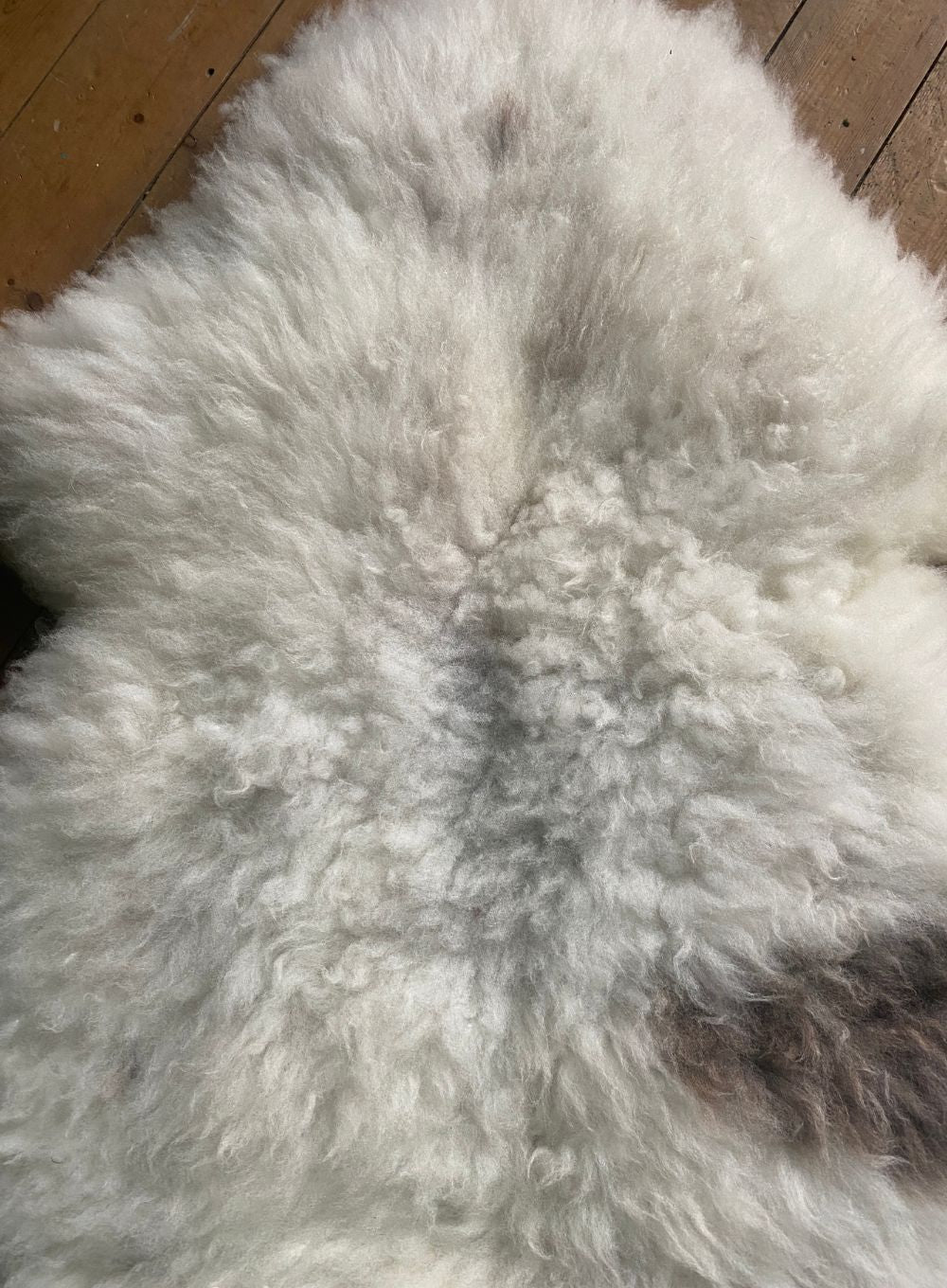 Cream sheepskin rug with brown spot close up