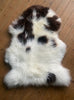 Brown and cream sheepskin rug on wooden floor 