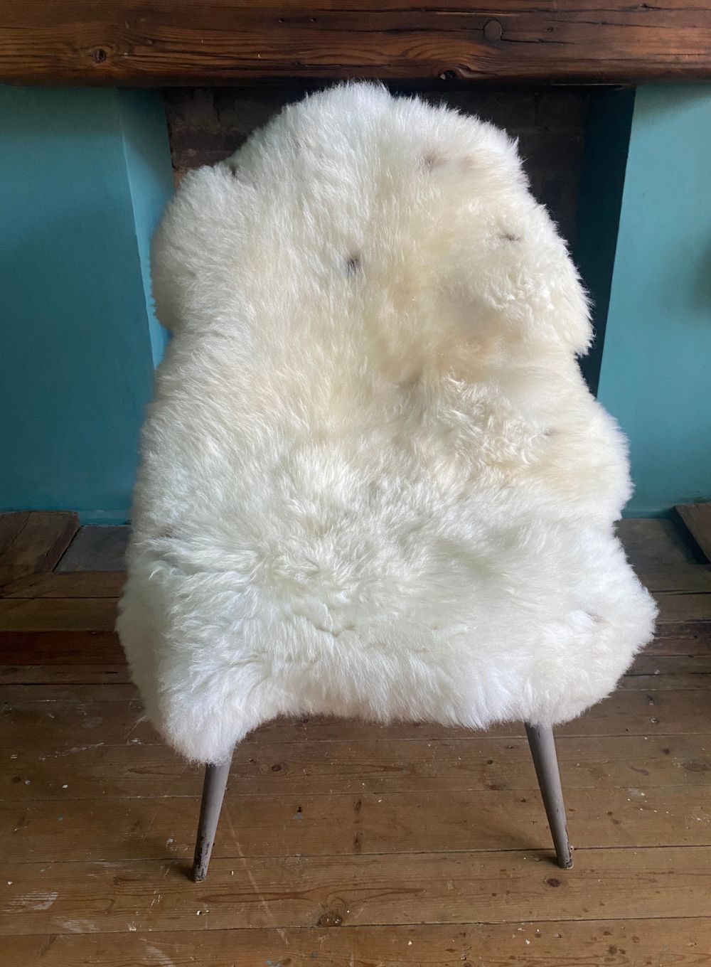 Cream speckled sheepskin rug on chair