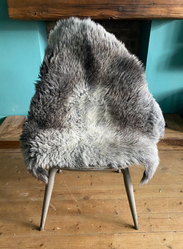Grey sheepskin rug on chair 