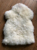 Cream sheepskin rug on wooden floor