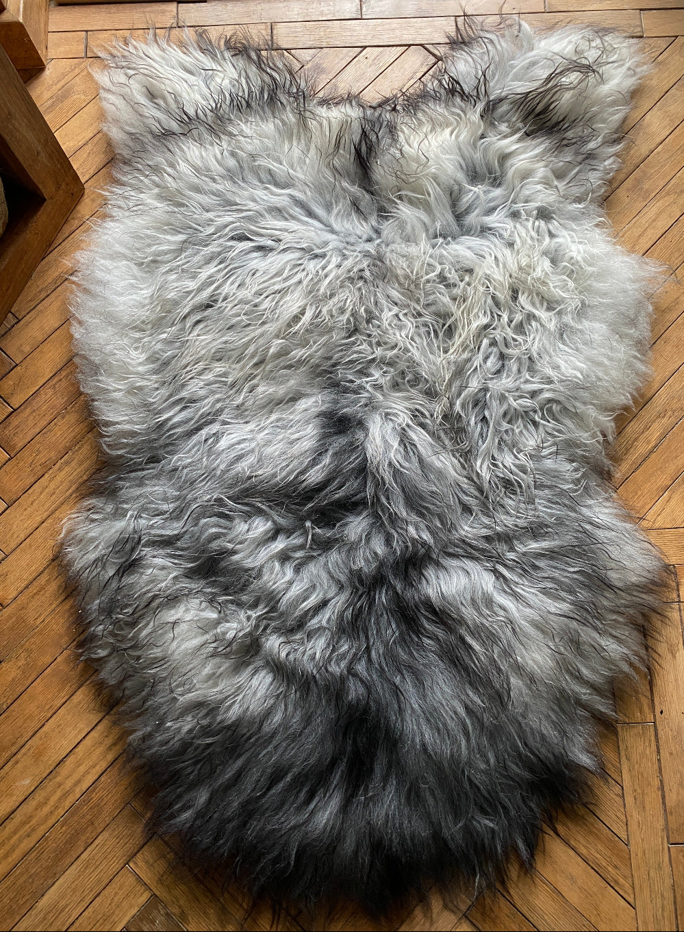 Grey and white sheepskin rug laid flat