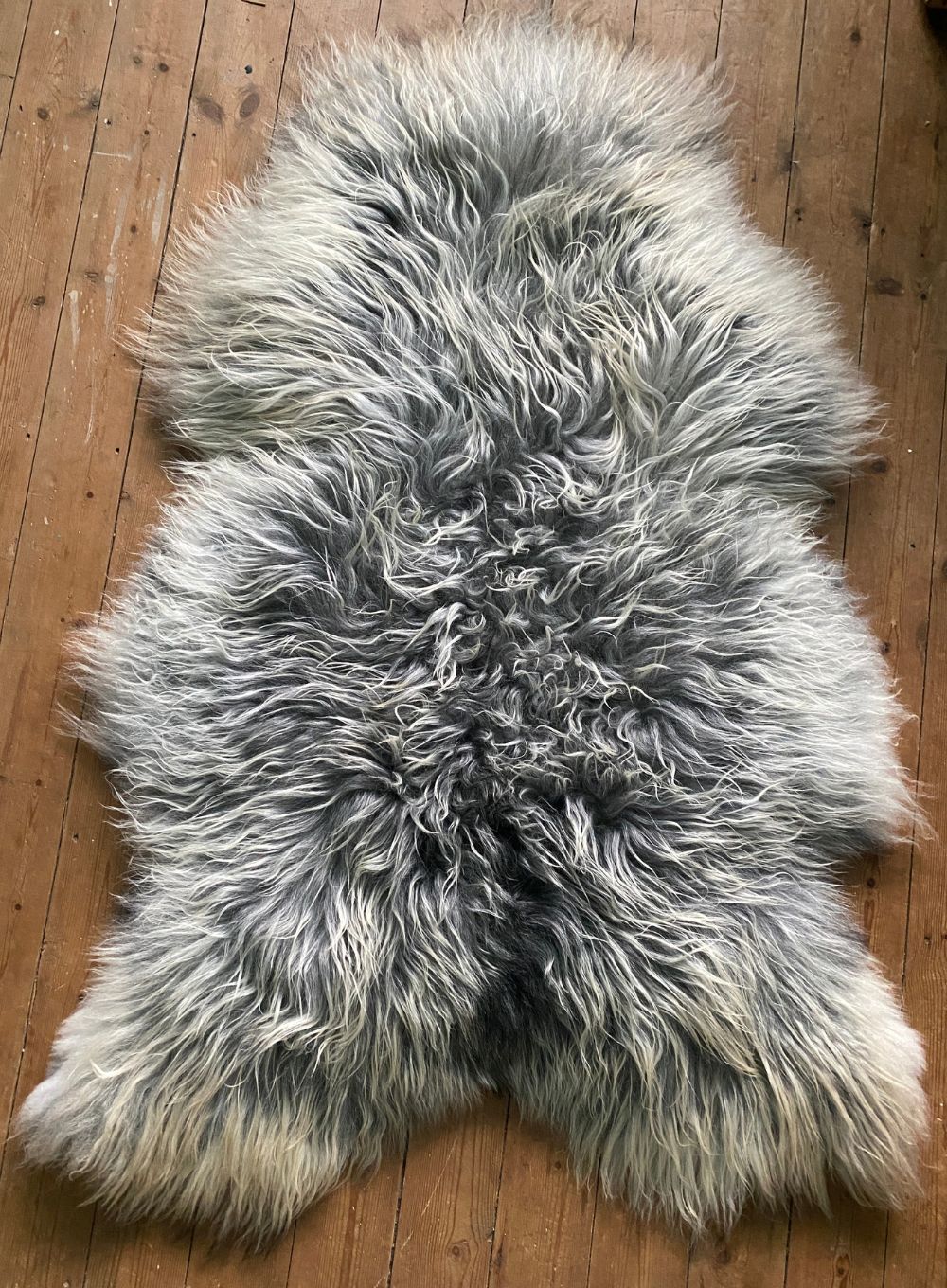 Long haired grey and cream sheepskin rug laid flat 
