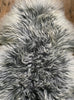 Long haired grey and cream sheepskin rug close up