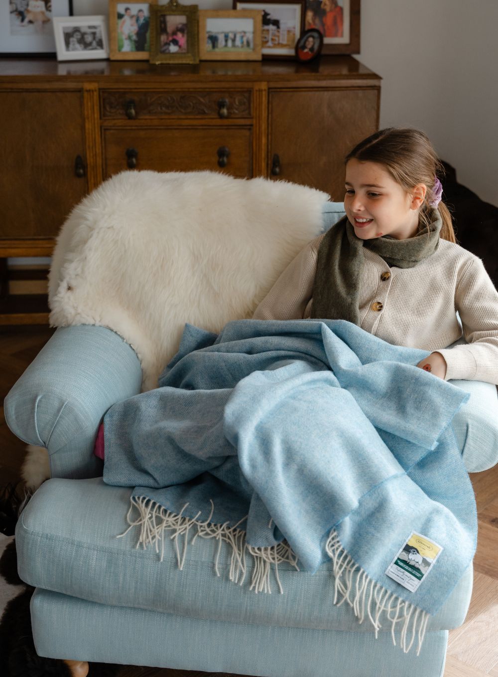 Girl wrapped in blanket on armchair