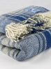 Blue plaid chunky wool travel rug rolled up