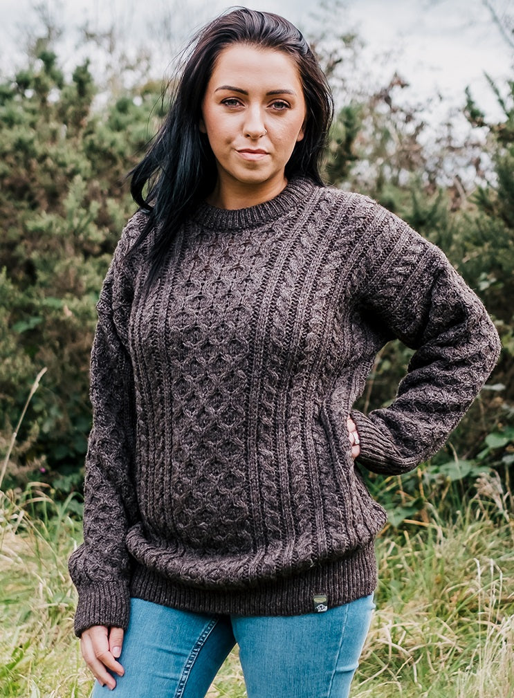 Female model wearing brown aran knitted jumper and jeans